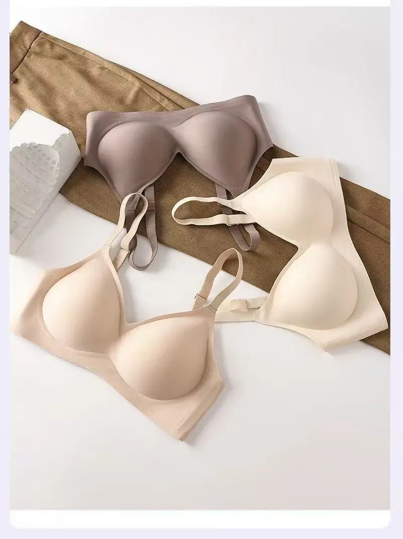 Two bras in beige and brown on a white surface with a brown fabric background.