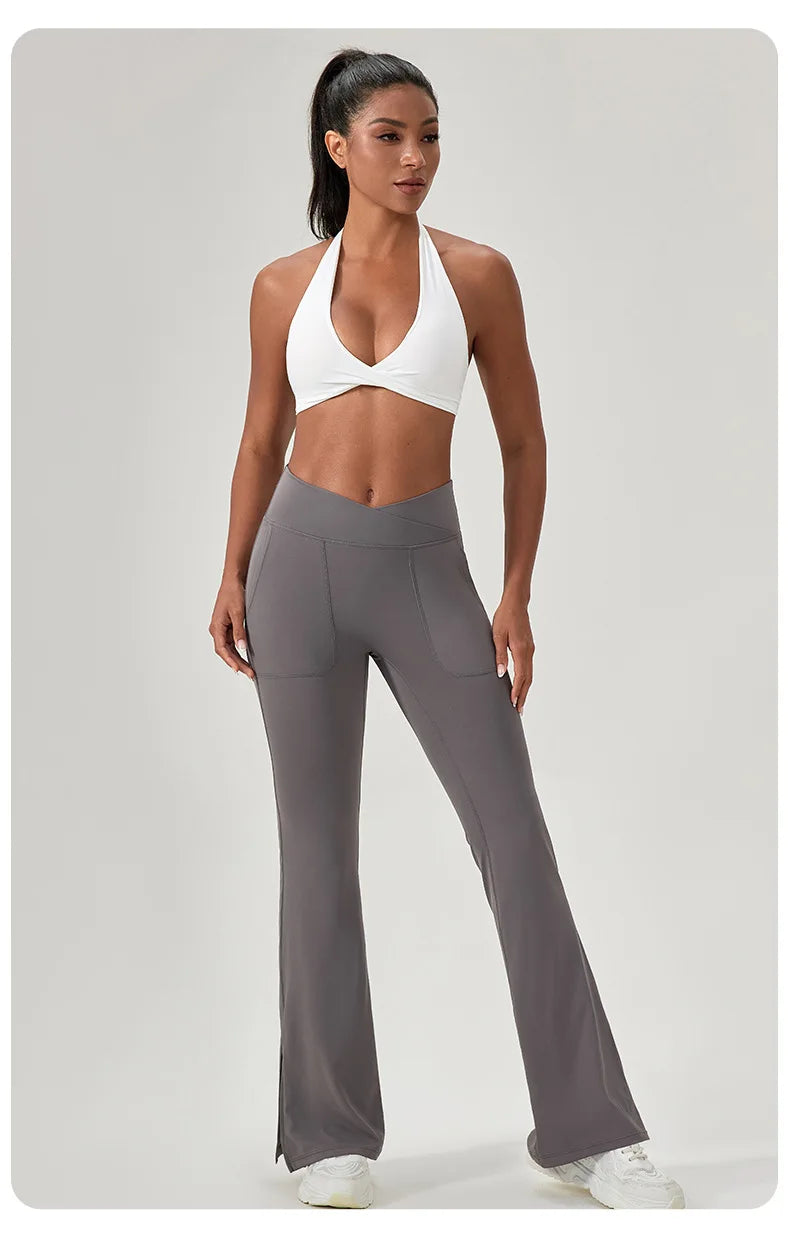 Woman wearing a white sports bra and gray leggings on a light gray background