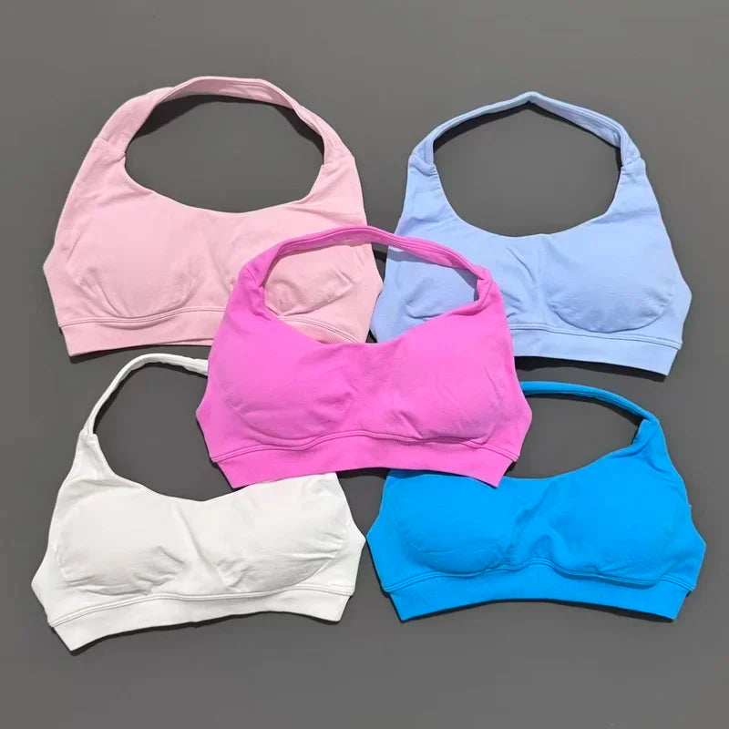 Five bras in pink, blue, white, and purple on a gray background