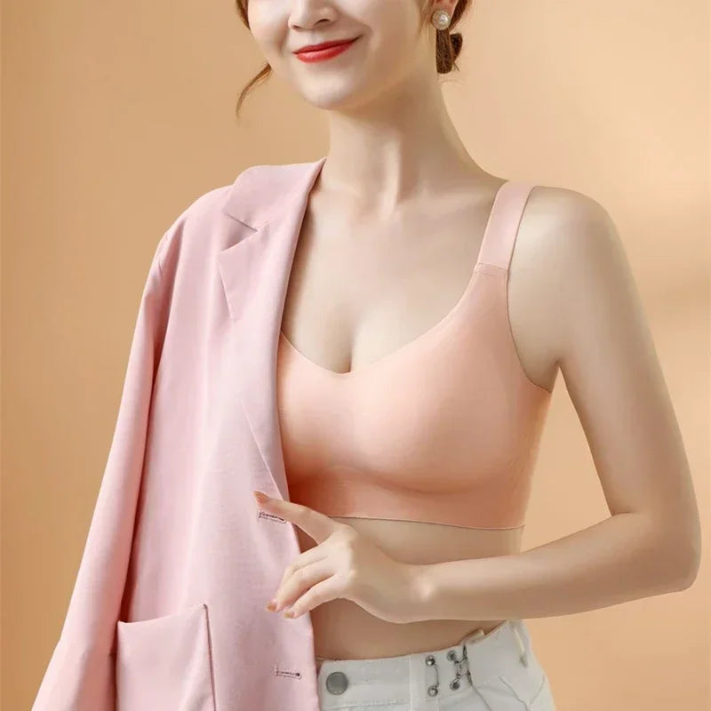 Woman wearing a pink top and light pink blazer against a beige background