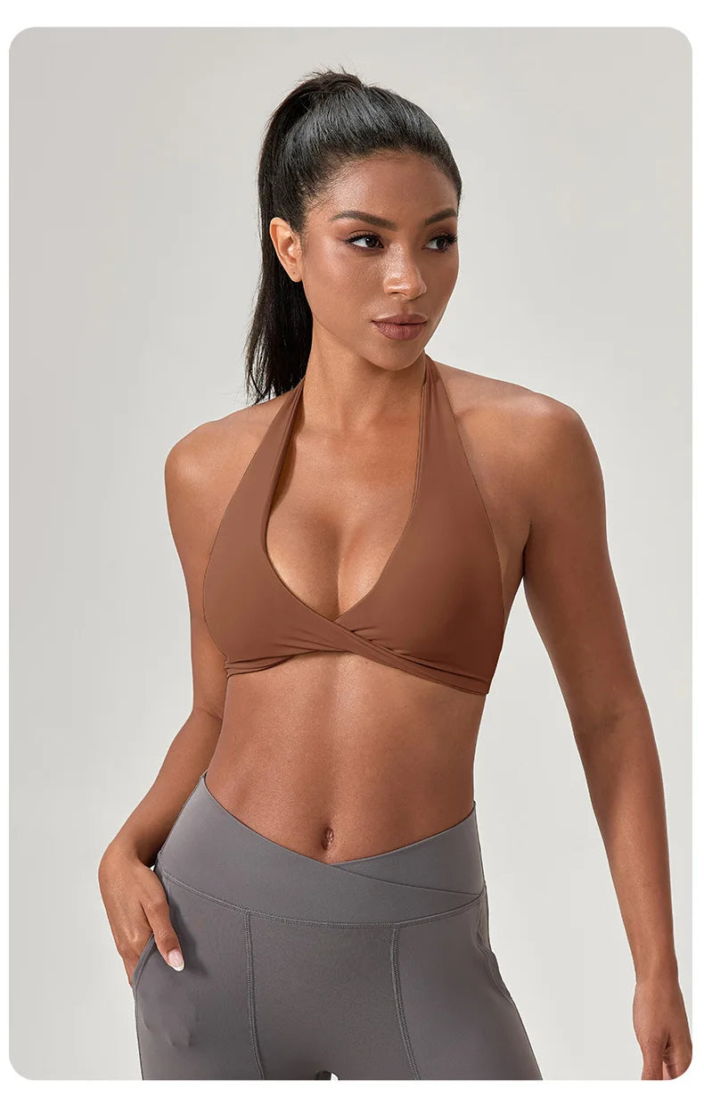 Woman wearing a brown sports bra and gray leggings on a light gray background