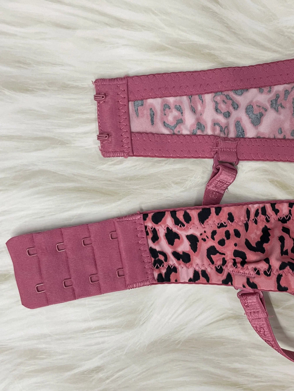 Pink dog harness with leopard print on a white fur background